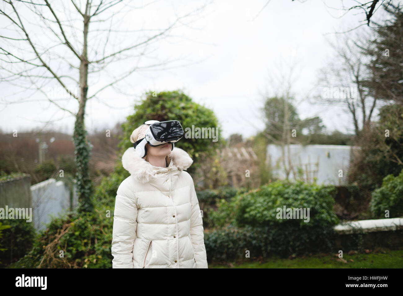 Manteau femme en fureur à l'aide de casque de réalité virtuelle à l'extérieur Banque D'Images Manteau femme en fureur à l'aide de casque de réalité virtuelle à l'extérieur Banque D'Images