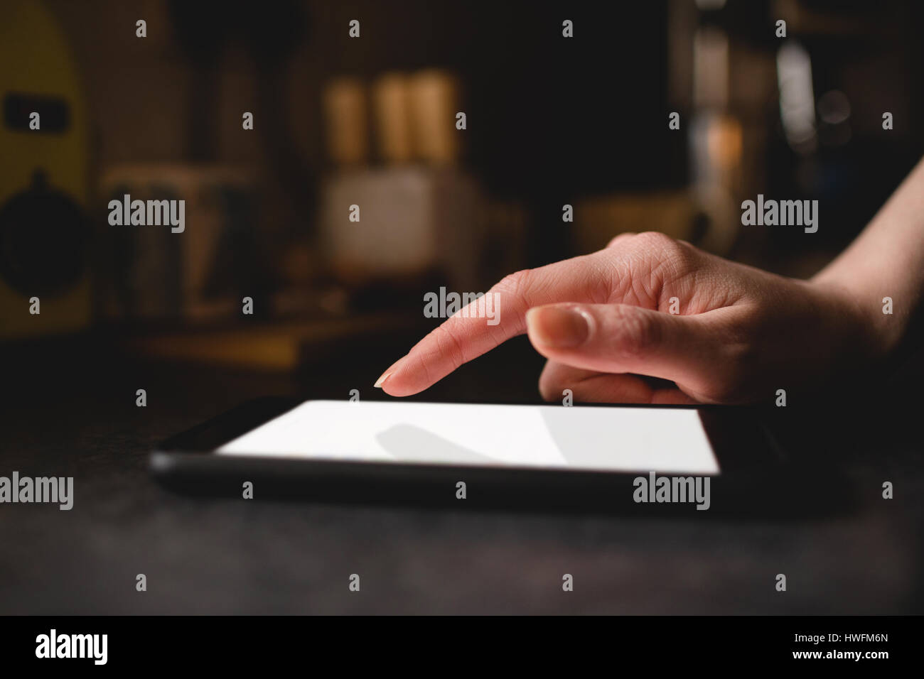 La main de womans using digital tablet in La cuisine à la maison Banque D'Images