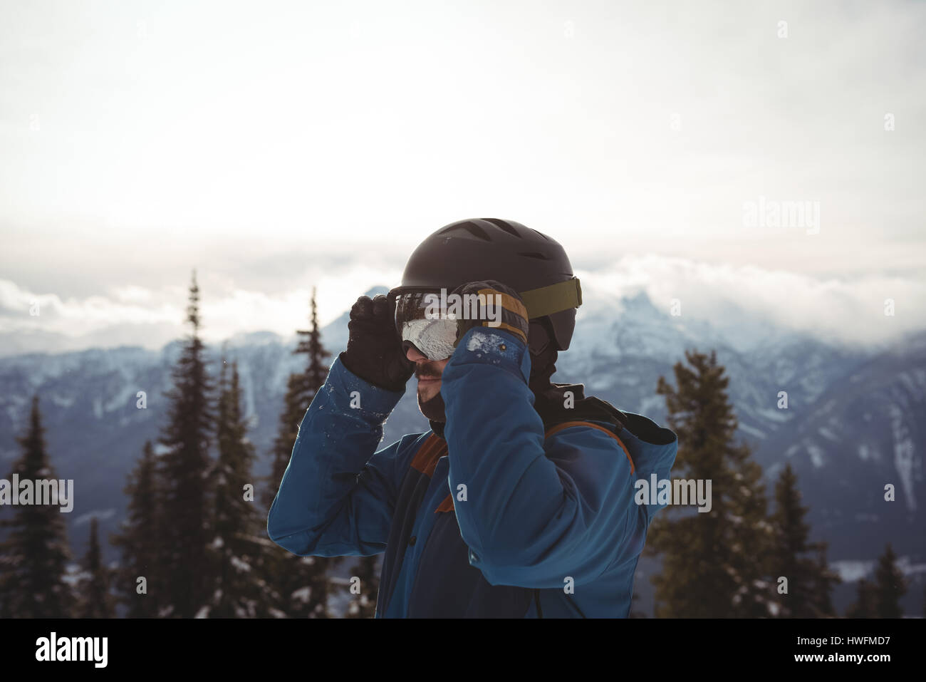 Homme portant un casque en montagne contre le ciel au cours de l'hiver Banque D'Images