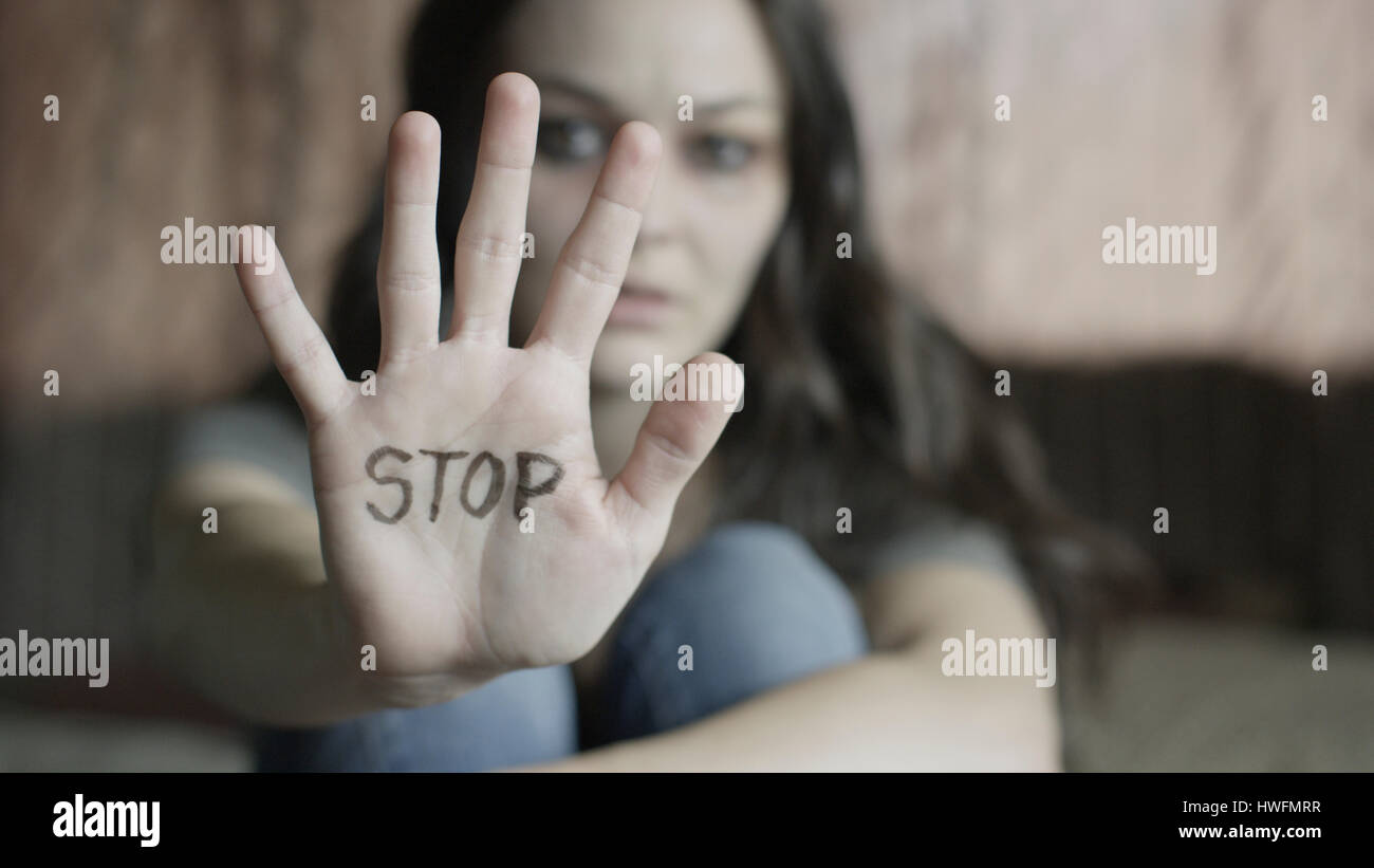 Close up of woman holding out hand avec STOP écrit on bed Banque D'Images