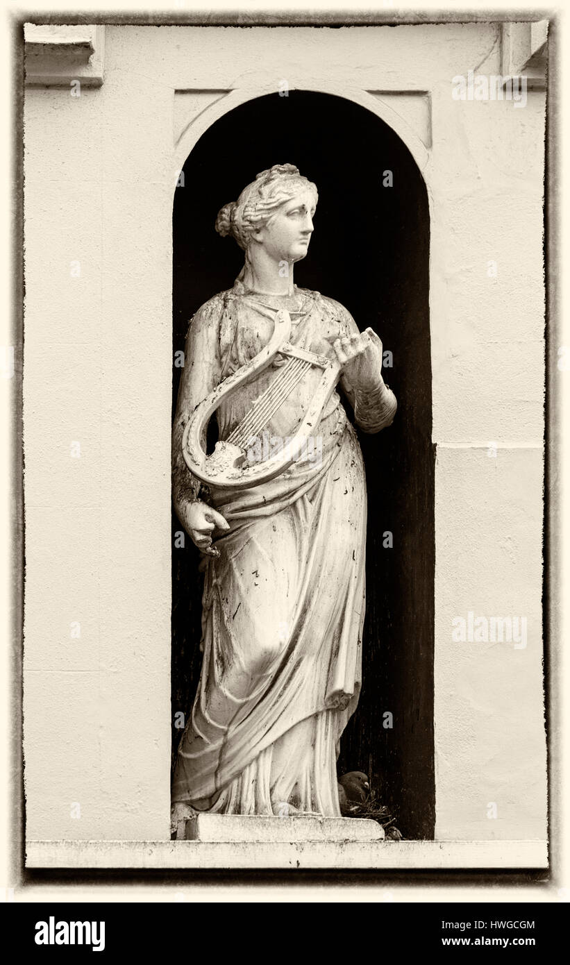 Cirencester - statue de femme avec lyre dans une alcôve de la construction à Dollar Street, Cirencester, Gloucestershire en Mars Banque D'Images