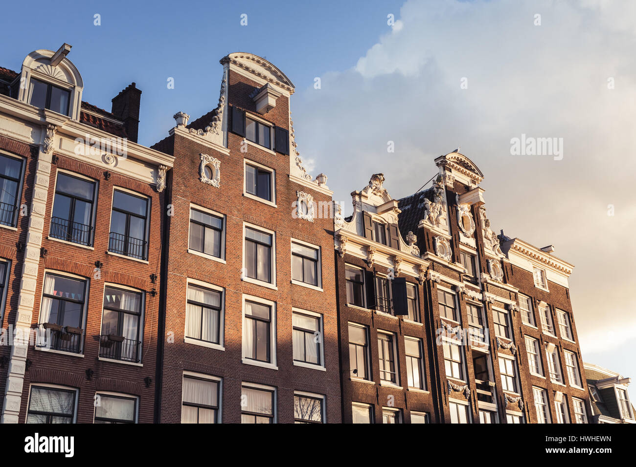 La vie traditionnelle des maisons de la vieille ville d'Amsterdam, Pays-Bas. Façades sur ciel nuageux Banque D'Images