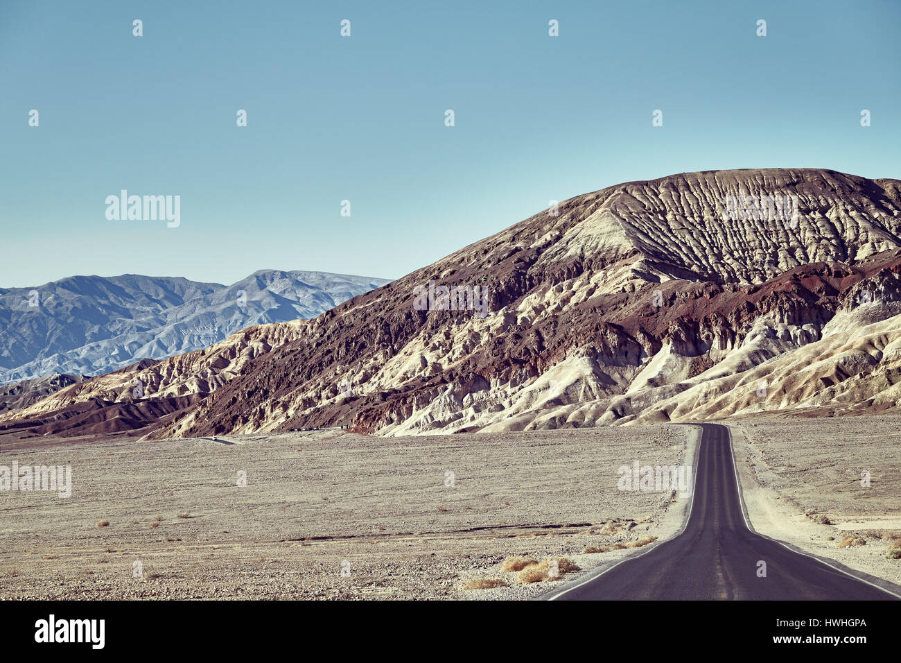 Route du désert en direction de montagnes à la vallée de la mort, aux tons de couleur libre, USA. Banque D'Images