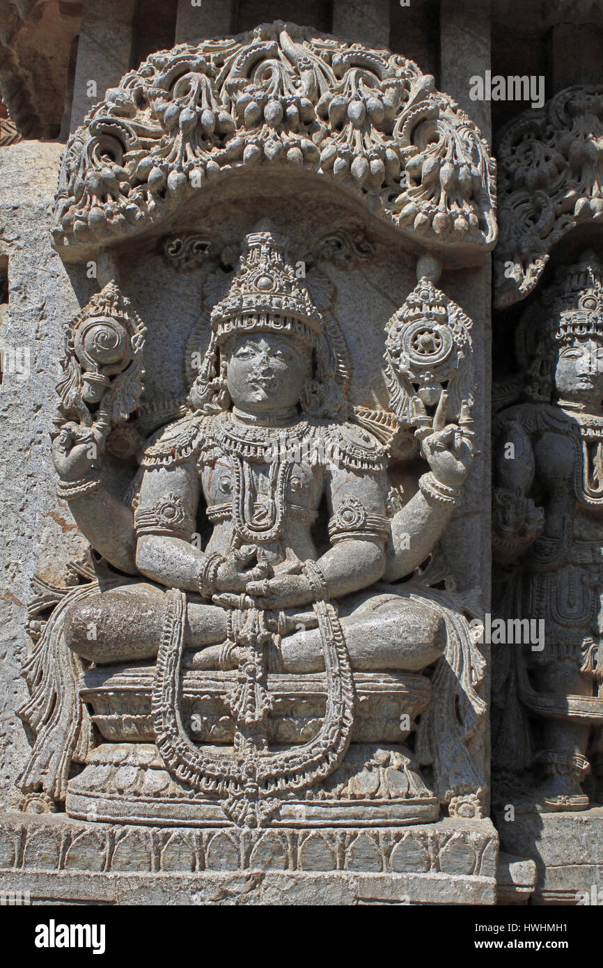 Close up of sculpture de pierre(yoga Narayana) seigneur Vishnu assis en posture de méditation, en vertu de l'eves sur la paroi extérieure de culte dans le Temple de Chennakesava, Hoys Banque D'Images