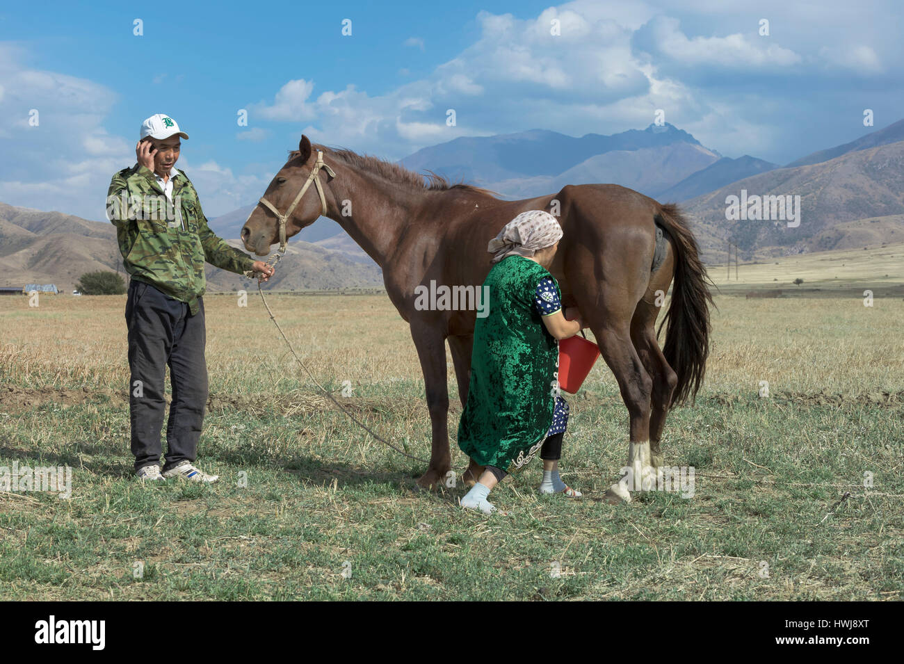 Homme Kazakh avec téléphone cellulaire et Kazakh Femme Gabagly traite une mare, parc national, Shymkent, Kazakhstan, Région du Sud, l'Asie centrale, pour un usage éditorial uniquement Banque D'Images