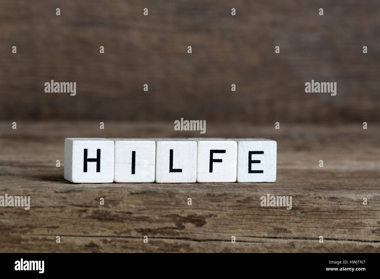 Mot allemand aide, écrit en cubes on a wooden background Banque D'Images