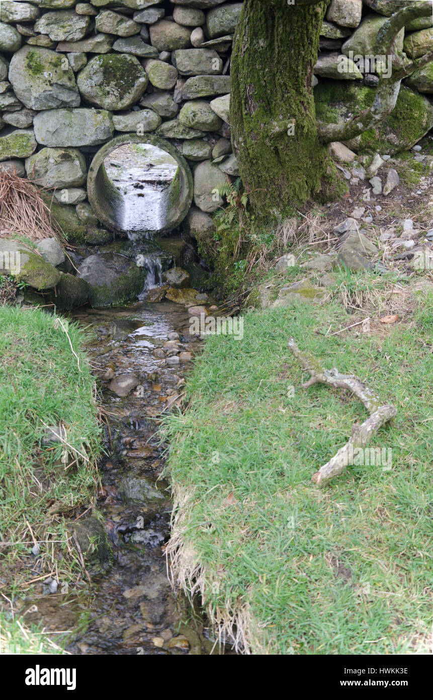 Le drainage du tuyau d'eau dans le mur de pierre autour d'un champ Photo  Stock - Alamy