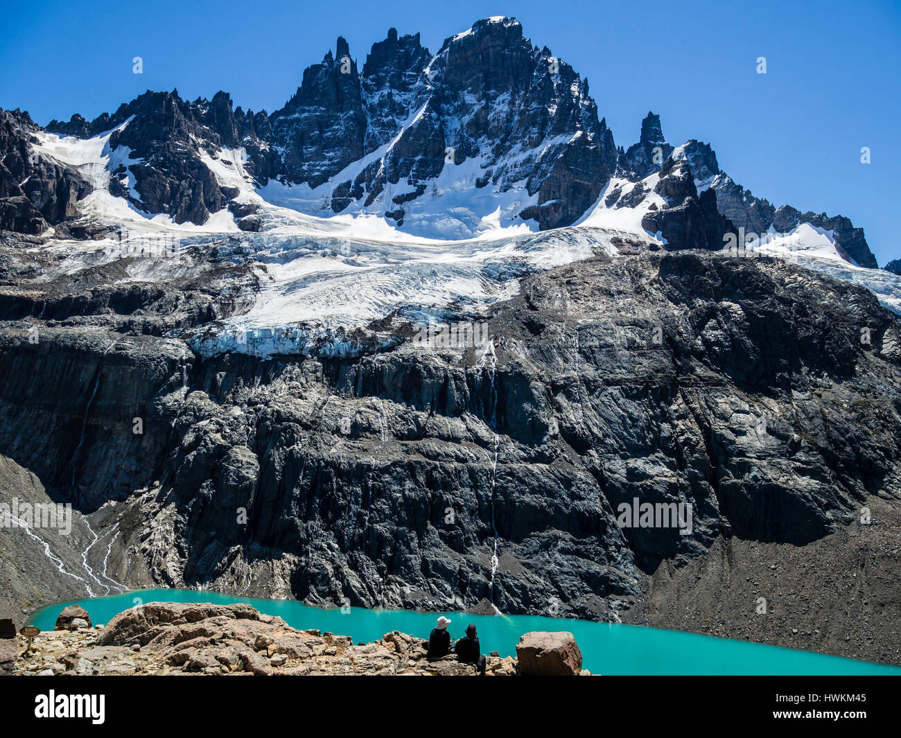 Couple assis au-dessus de la montagne Cerro Castillo lagon ci-dessous, vue vers la pointe de glacier et de Cerro Castillo, la réserve naturelle du Cerro Castillo, Reserva N Banque D'Images