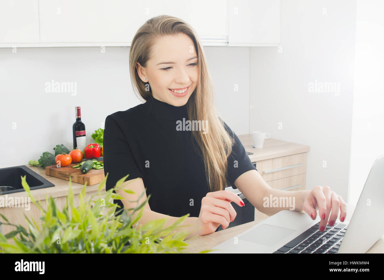 Jeune femme souriante avec ordinateur portable dans la cuisine. cuisine jeune femme cuisine portable alimentation manger sain concept Banque D'Images