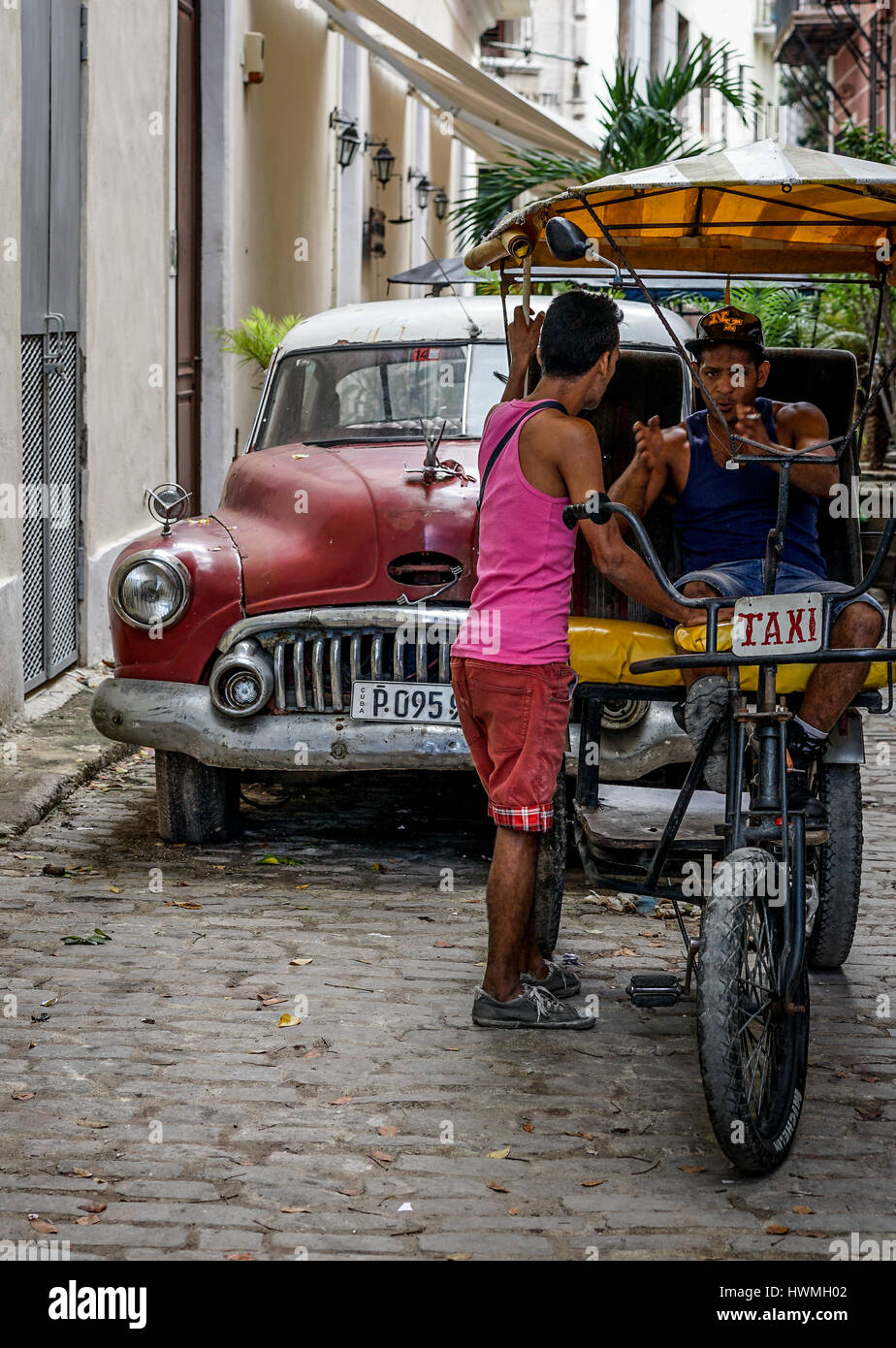La Havane, Cuba - le 5 janvier 2016 : scène typique de l'un des rues dans le centre de La Havane - vieilles voitures et Rickshaw vélo taxi Banque D'Images