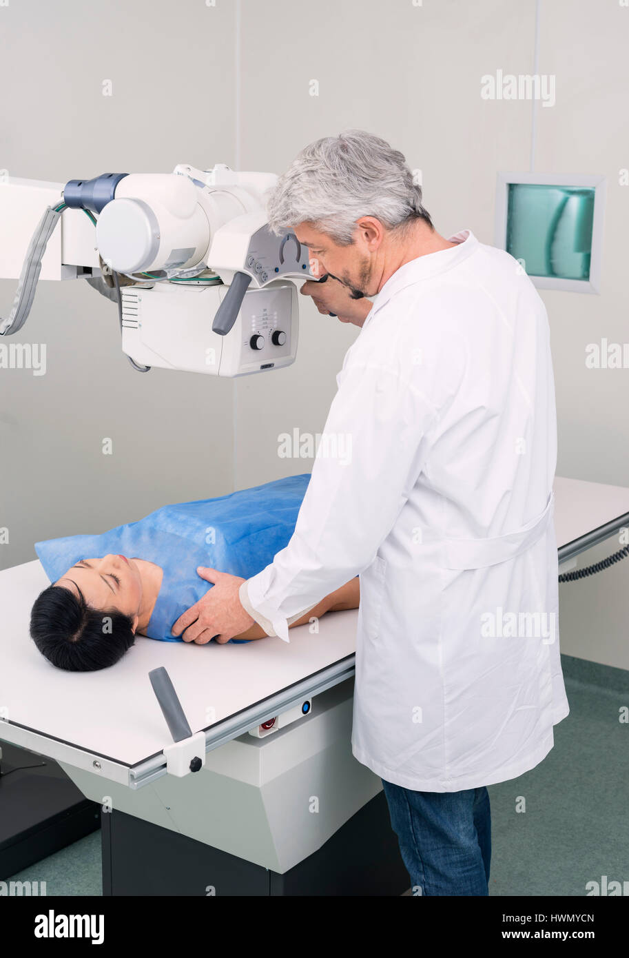 Radiologue mâle Réglage de machine à rayons X plus de patient dans Hospital Banque D'Images