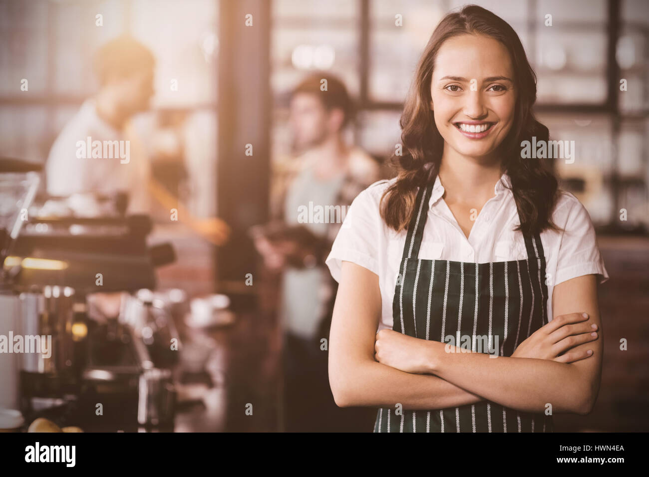 Flare contre jolie barista with arms crossed Banque D'Images