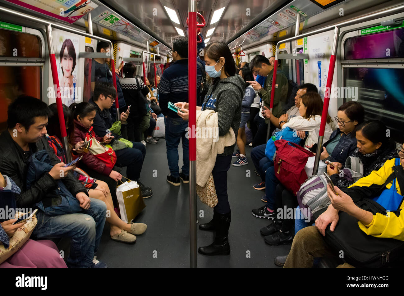 Les passagers utilisant des téléphones mobiles sur la station de métro