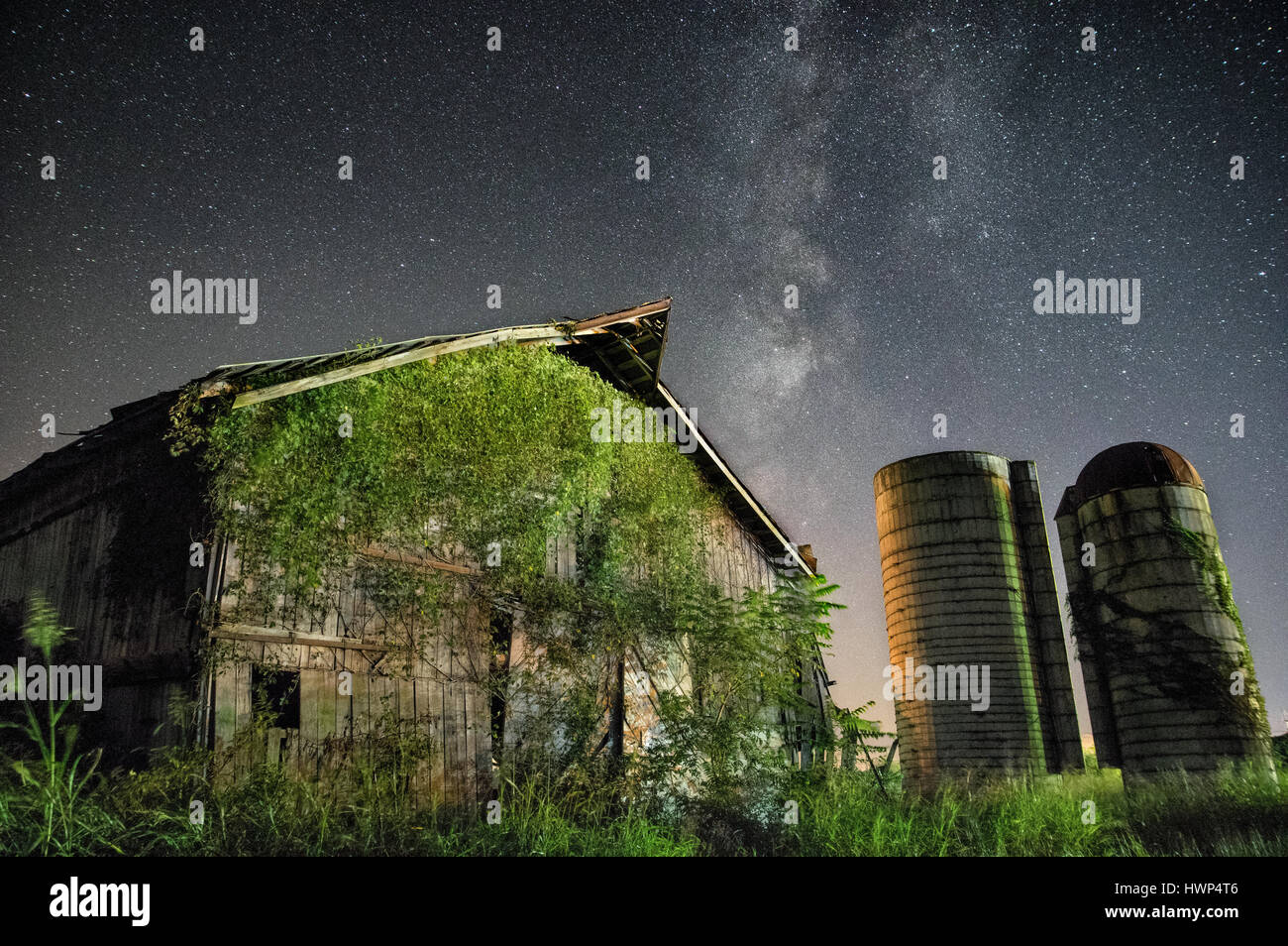 Le passé pas si lointain est vu à travers une vieille grange tenant fermement sous le poids de la nature, tandis que les étoiles derrière un tableau d'un mor Banque D'Images