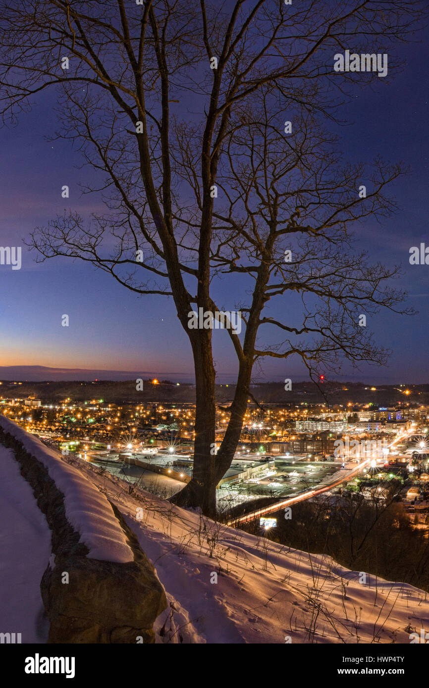 La lueur de la ville est reçu par la neige laden hills au crépuscule comme les étoiles apparaissent pour marquer la fin de la journée. Rotary Park, Huntington, West Virginia. Banque D'Images