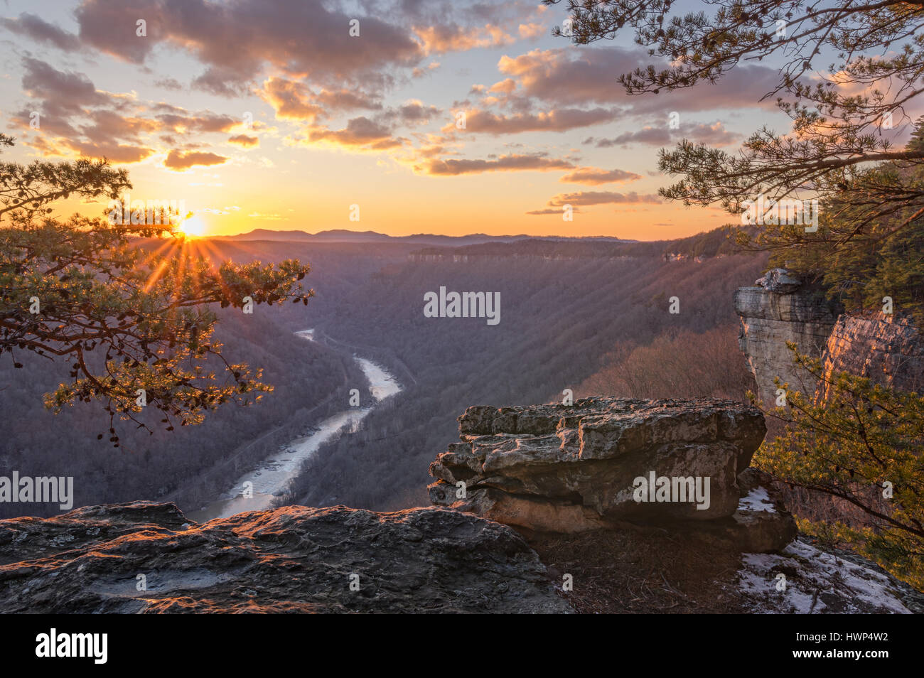 Le rendement des arbres à l'hiver, et le soleil qui met en lumière l'craggy rim et les conifères de la New River Gorge en Virginie occidentale. Banque D'Images
