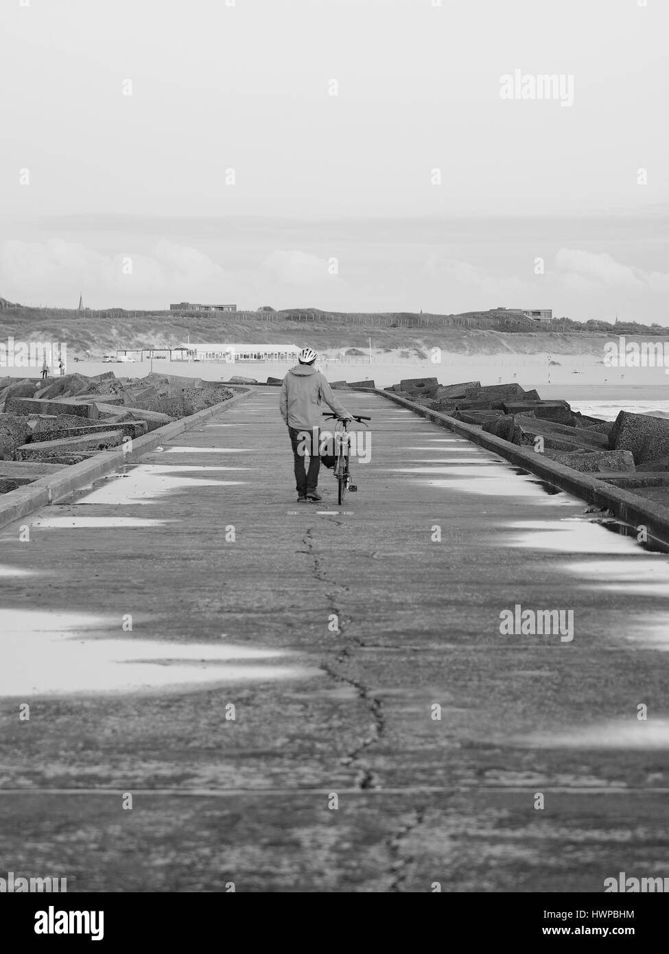 La Haye, Pays-Bas - le 7 juillet 2016 : les vélos piétons poussant le long d'un pilier de béton vers un retour en noir et blanc Banque D'Images