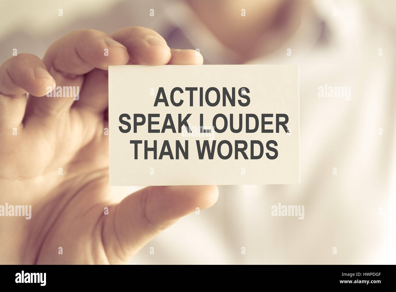 Gros plan sur businessman holding une carte avec du texte Les actes parlent plus que les mots, l'image du concept d'entreprise avec l'arrière-plan flou et vintage tone Banque D'Images