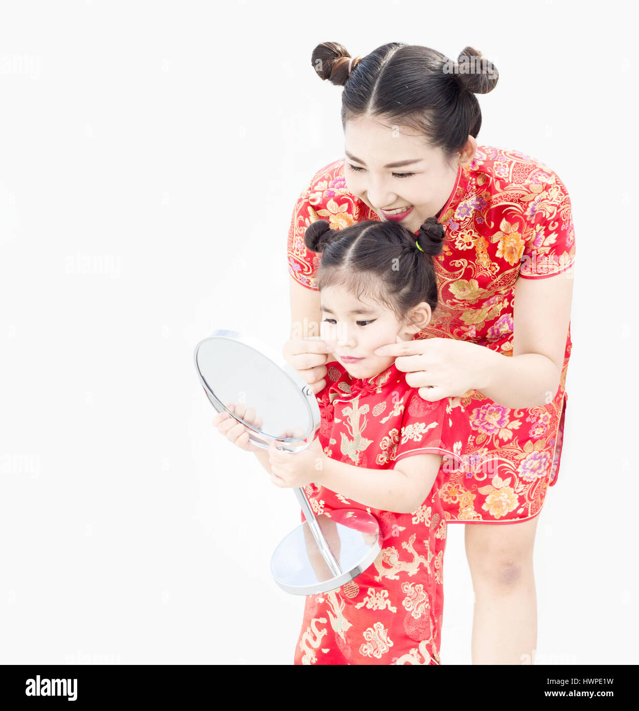 Maman asiatique et duagther composent le visage et s'habiller en qipoa cheongsam robe chinoise traditionnelle dans le festival Banque D'Images