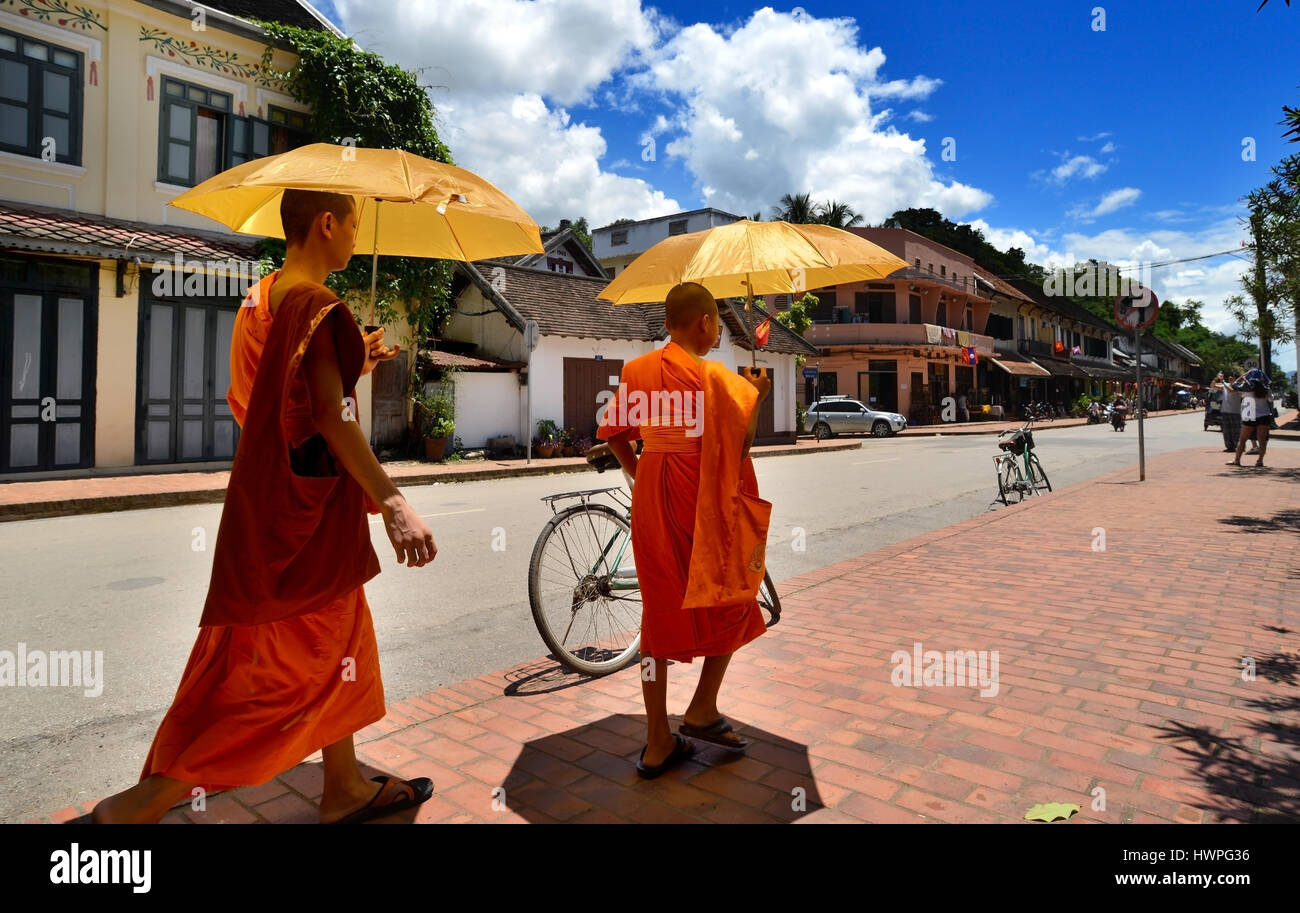Loungprabang, Laos - Août 7, 2015 : peu de non identifiés 2 moines se balade dans la rue avec sun protection parapluie. Banque D'Images