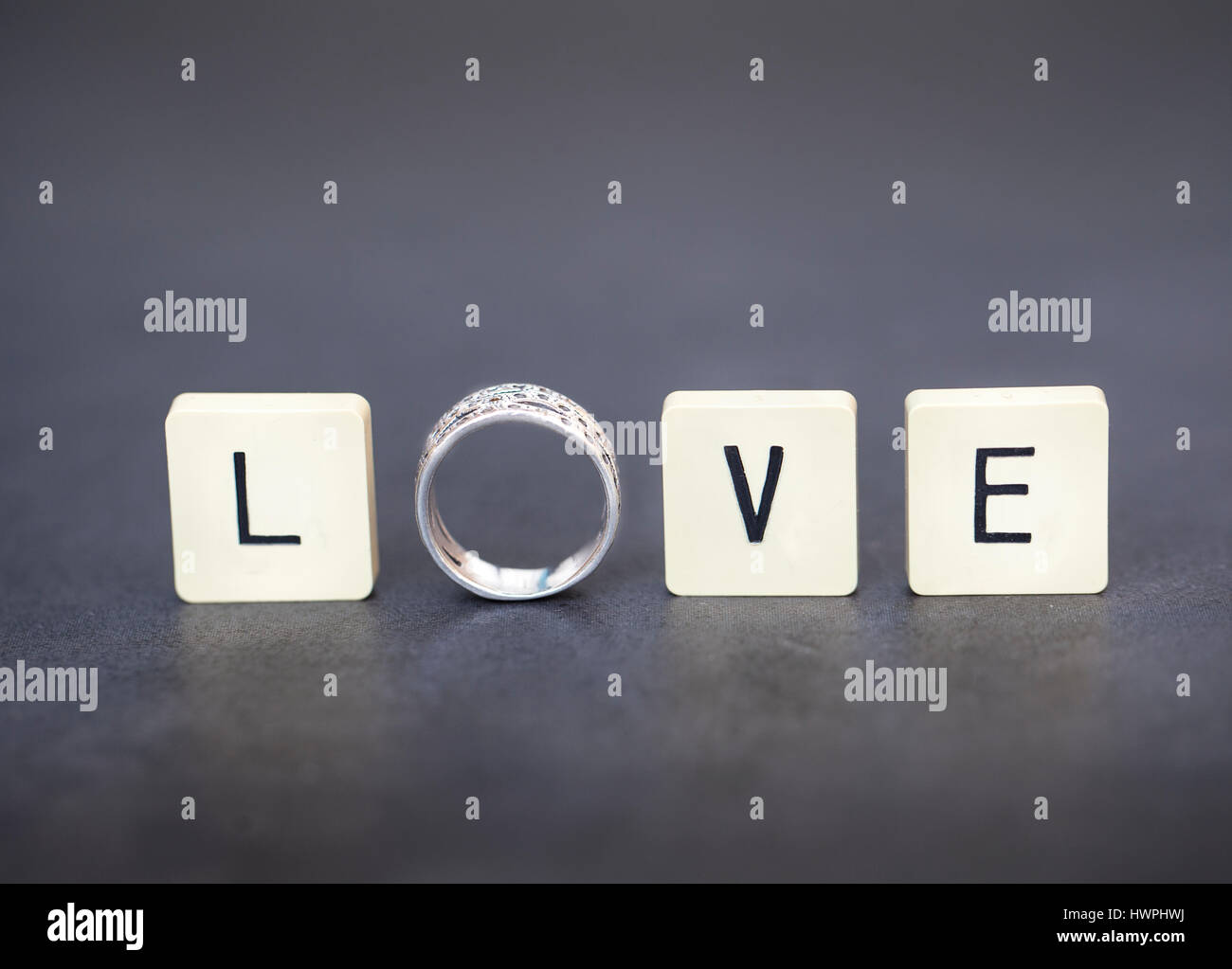 Lettre carreaux et l'anneau de l'orthographe le mot 'Amour'. Image conceptuelle pour l'Amour, mariage, mariage, fiançailles, etc... Banque D'Images