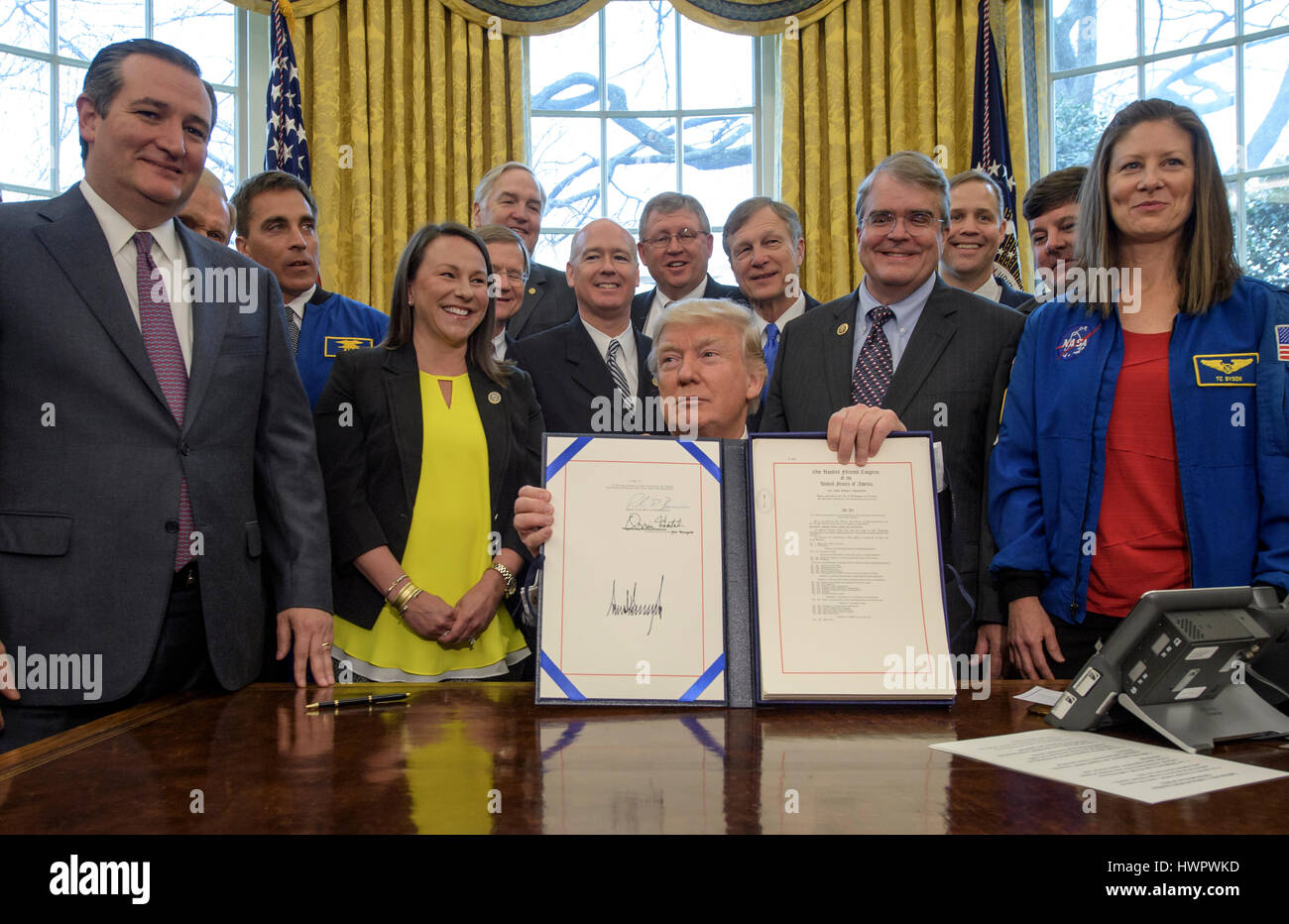 Le Président américain Donald Trump entouré par les politiciens et les astronautes détient la copie signée de la transition de la NASA Authorization Act de 2017 dans le bureau ovale de la Maison Blanche, le 21 mars 2017 à Washington, D.C. Banque D'Images