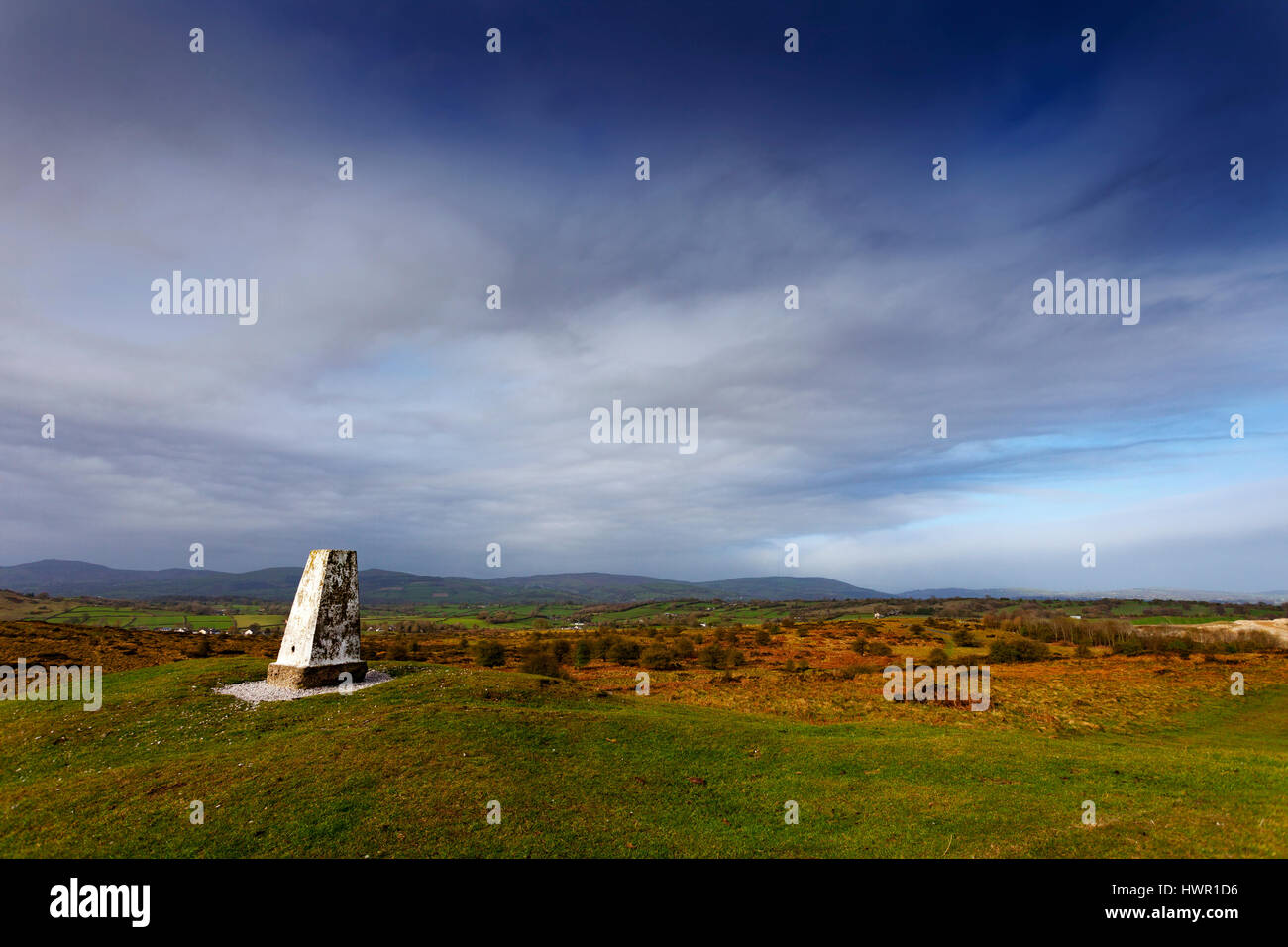 Trig point sur Halkyn Mountain comme les nuages se forment au cours de la gamme Clwydian Hills dans la distance Banque D'Images