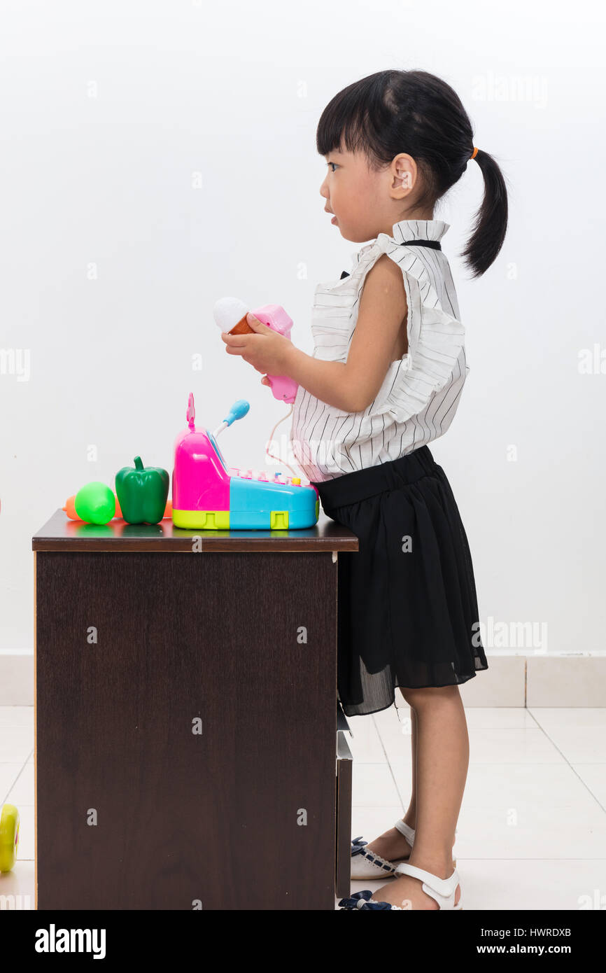 Petite fille chinoise asiatique semblant comme caissière avec des jouets  dans isolé sur fond blanc Photo Stock - Alamy