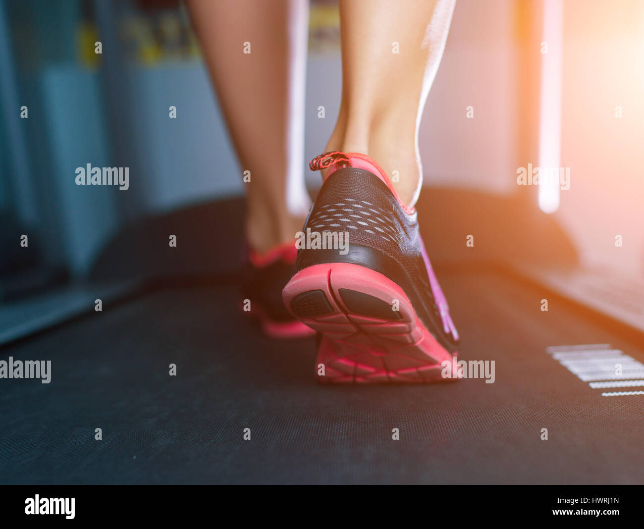 La femelle les pieds dans des chaussures d'exécution sur le tapis roulant à la salle de sport. Concept de la condition physique, l'exercice et mode de vie sain Banque D'Images