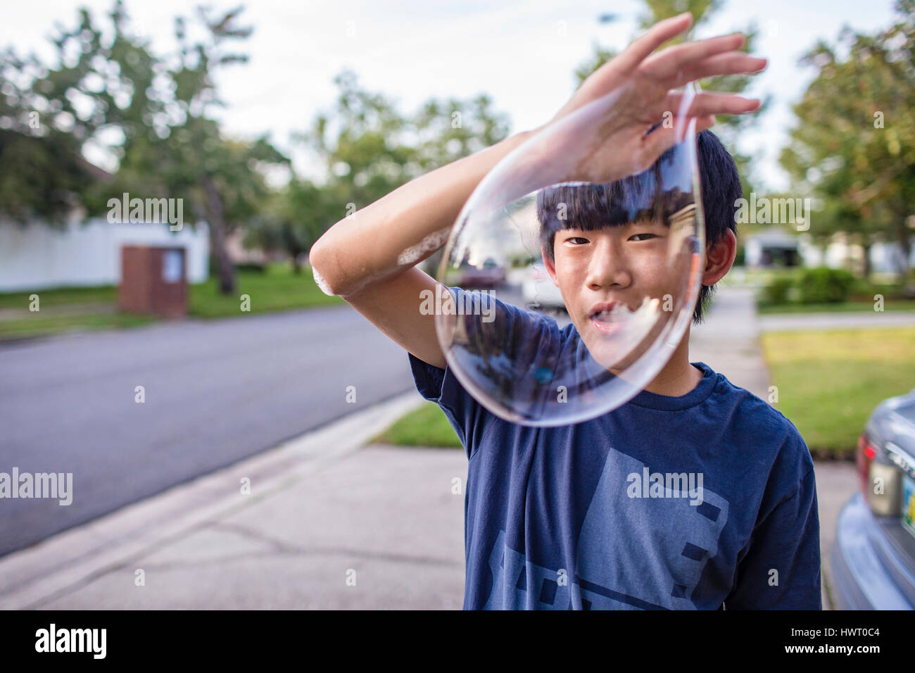 Portrait of teenage boy avec bulle debout sur sentier Banque D'Images