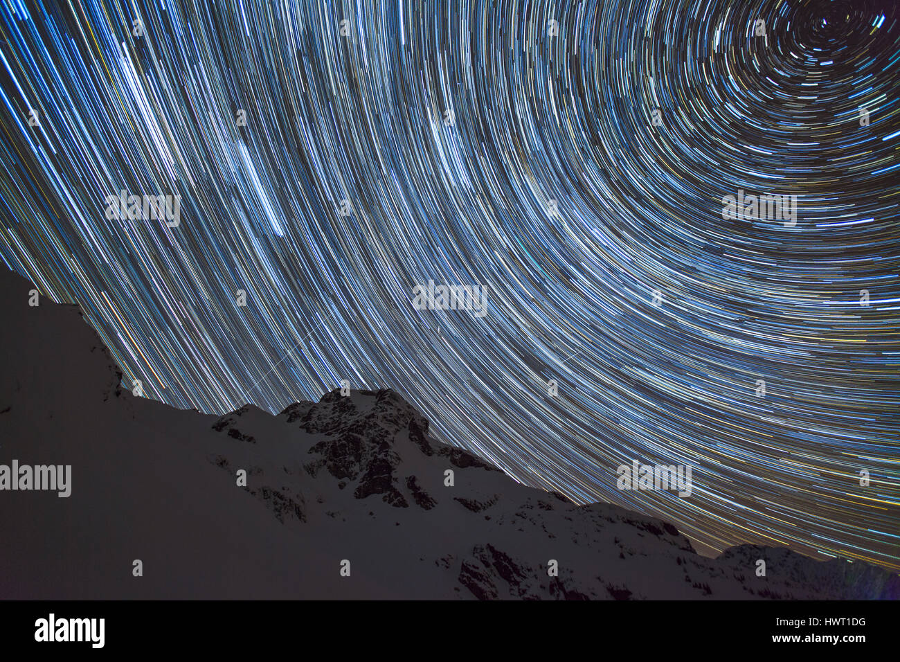Low angle view of star trail contre la montagne de nuit silhouette Banque D'Images