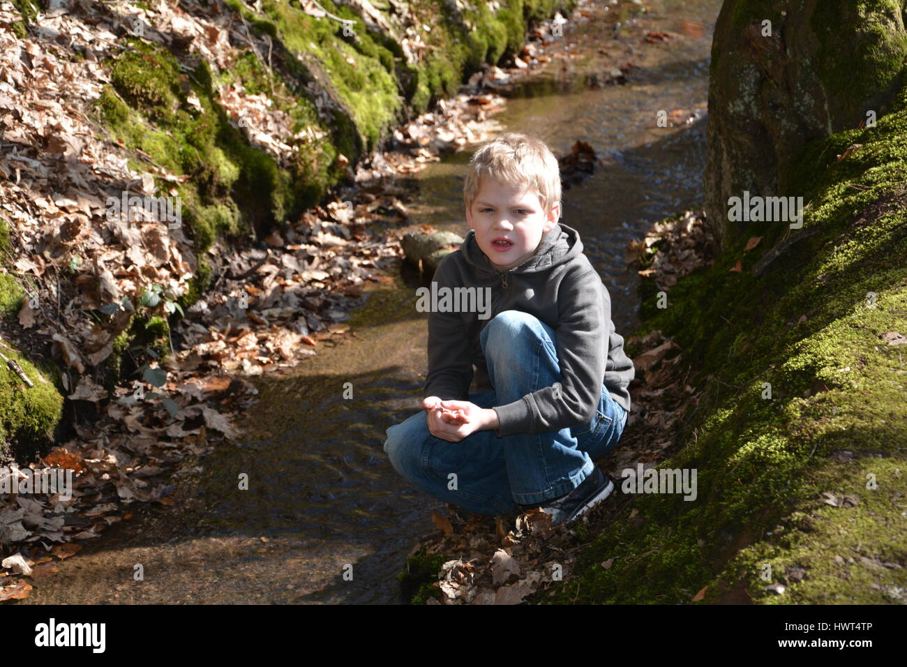 Petit garçon dans le ruisseau conserve malheureusement main blessée Banque D'Images