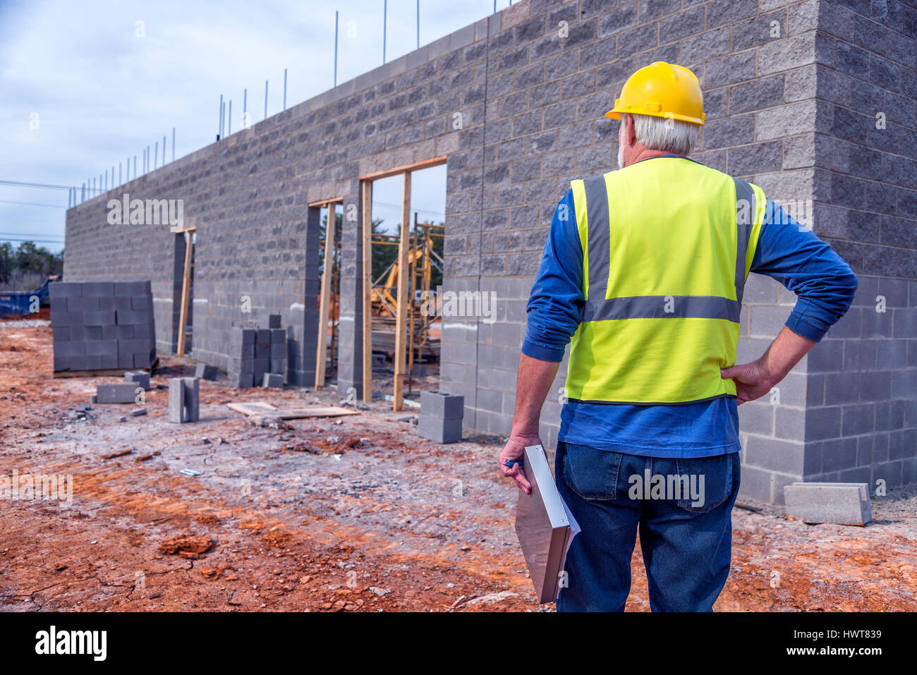 Un superviseur aux cheveux gris et inspecte les nouveaux points de la construction. Banque D'Images
