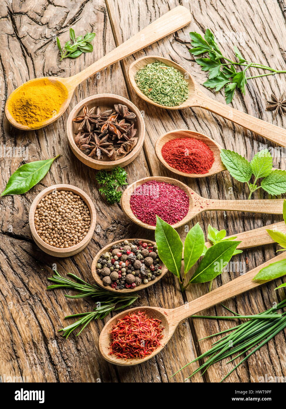 Assortiment de cuillères en bois dans les épices et herbes sur la table en bois. Banque D'Images