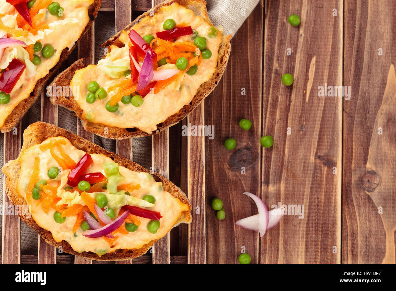 Cuisine italienne. Bruschetta à la sauce, petits pois, carotte, feuilles de chou et le poivre. Banque D'Images