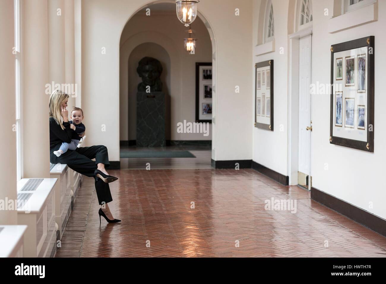 Ivanka Trump, fille du président américain Donald Trump tient son plus jeune fils Theodore comme elle parle au téléphone dans le Moyen-Orient Colonnade de la Maison Blanche le 29 janvier 2017 à Washington, D.C. Banque D'Images