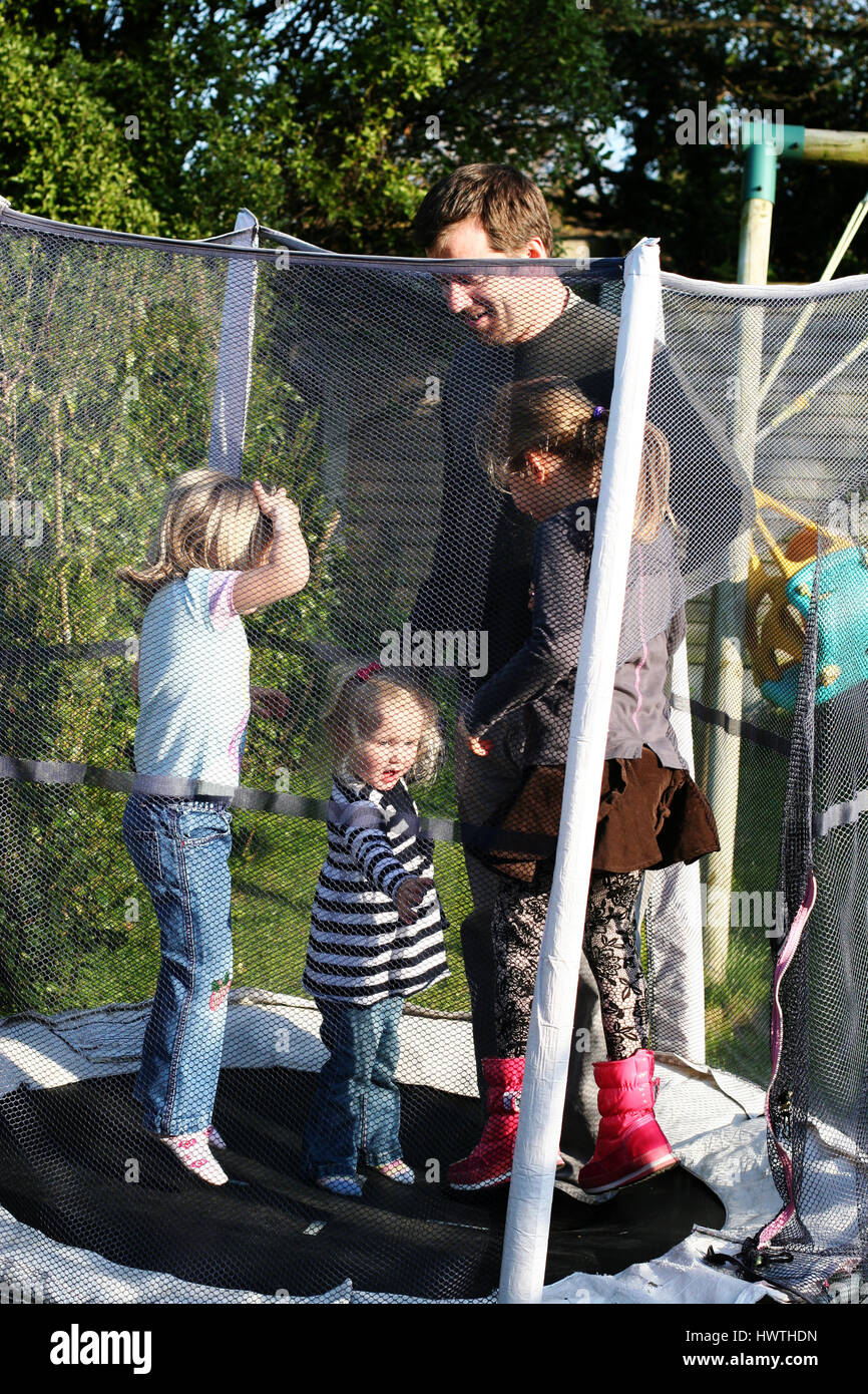 Papa et ses filles qui rebondit sur le trampoline père fille concept Banque D'Images