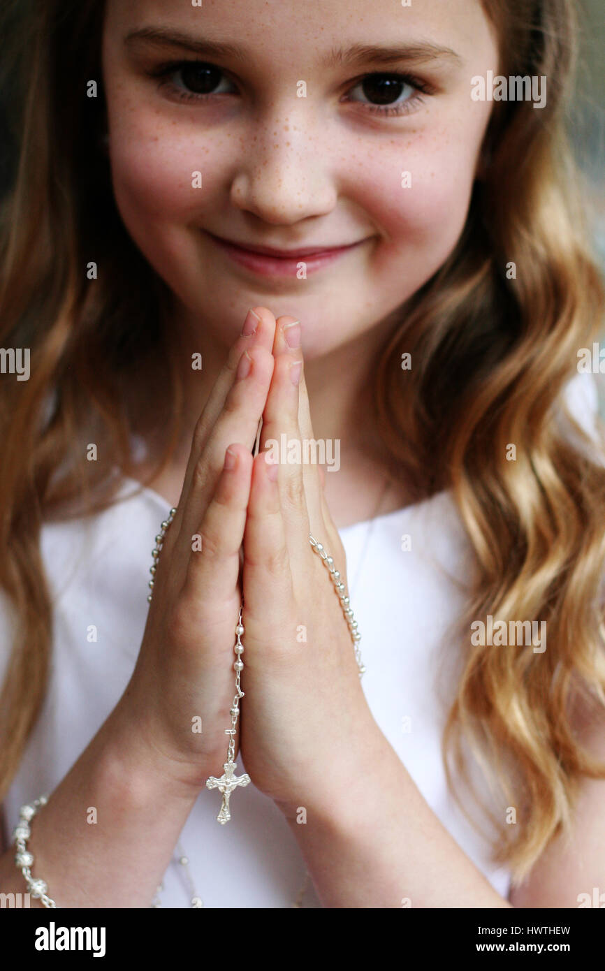 Girl smiling dans sa robe de communion blanche Banque D'Images