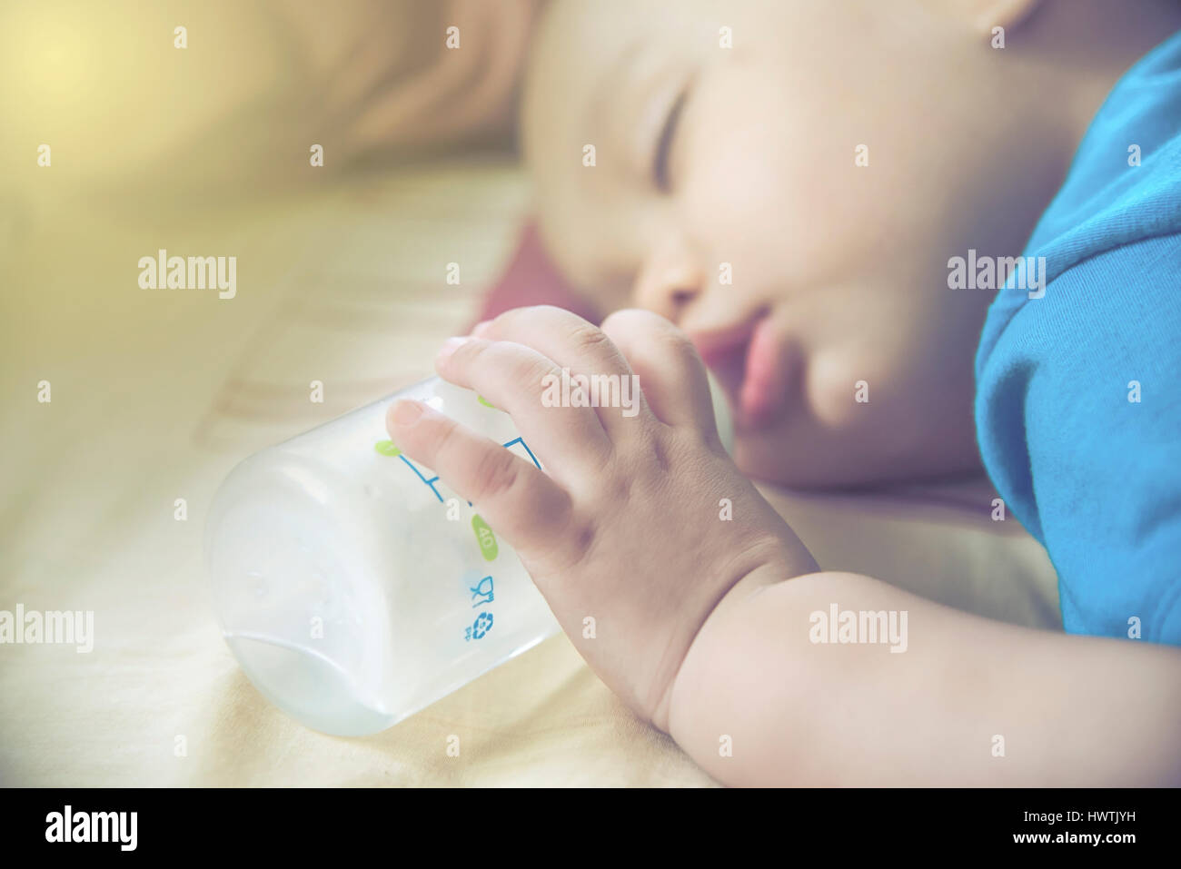 Bébé gros plan main et des doigts . Baby holding bottle pendant le sommeil Banque D'Images