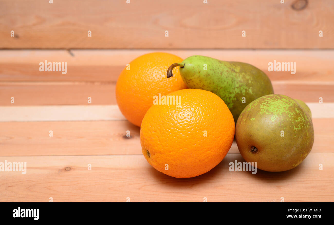 Les poires et les oranges sur le fond en bois Banque D'Images