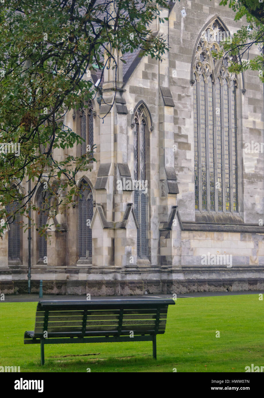 Banc dans le jardin de la première Église d'Otago et la grande fenêtre gothique du transept - Dunedin, île du Sud, Nouvelle-Zélande Banque D'Images