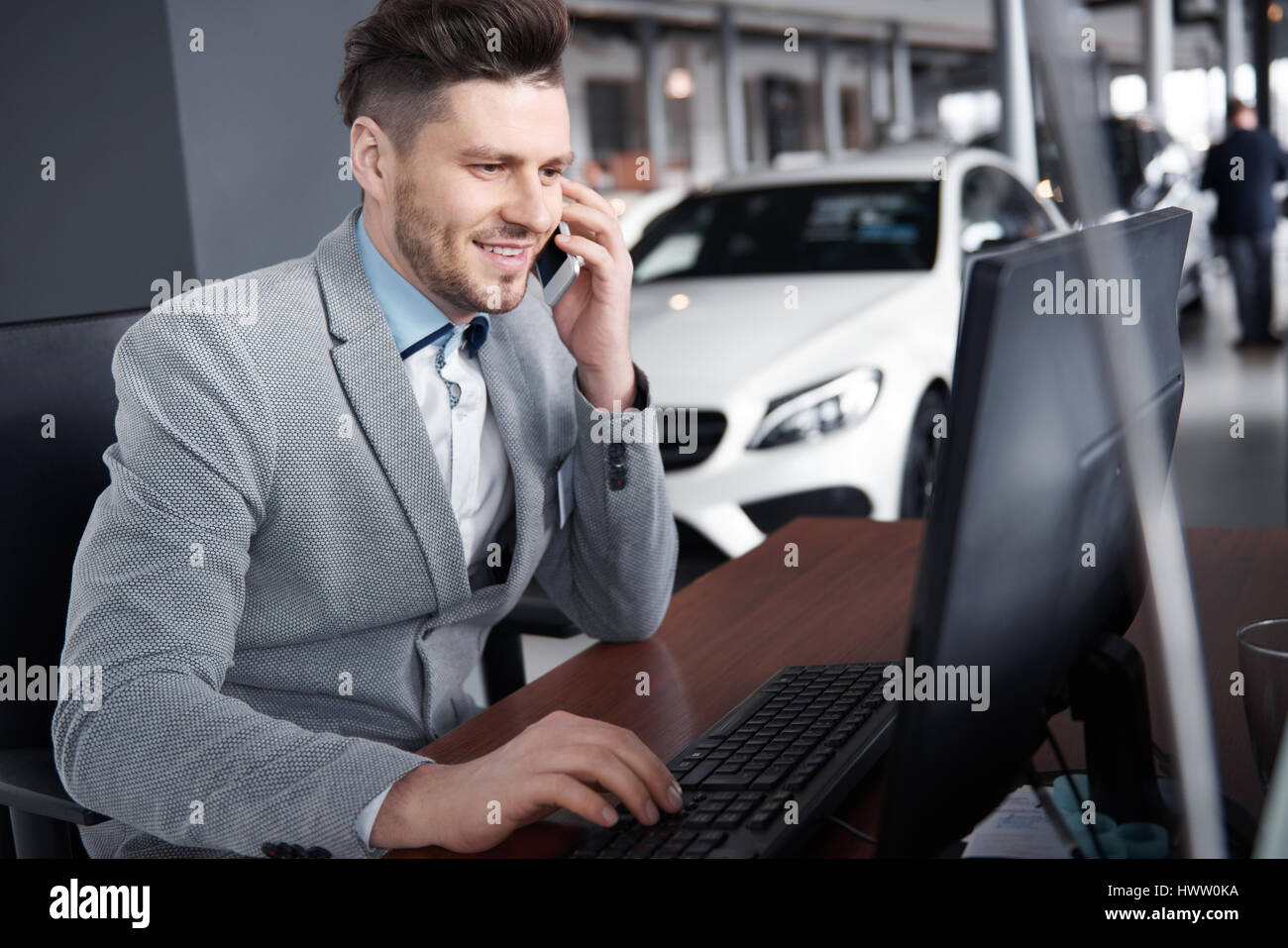 Marchand de voiture au téléphone à parler avec le client Banque D'Images