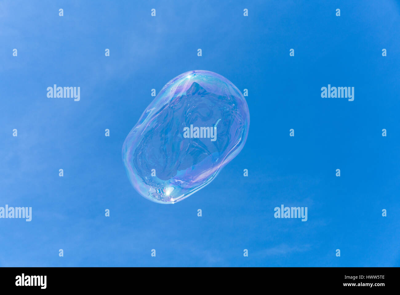 Une bulle de savon flottant dans le ciel bleu avec des réflexions Banque D'Images