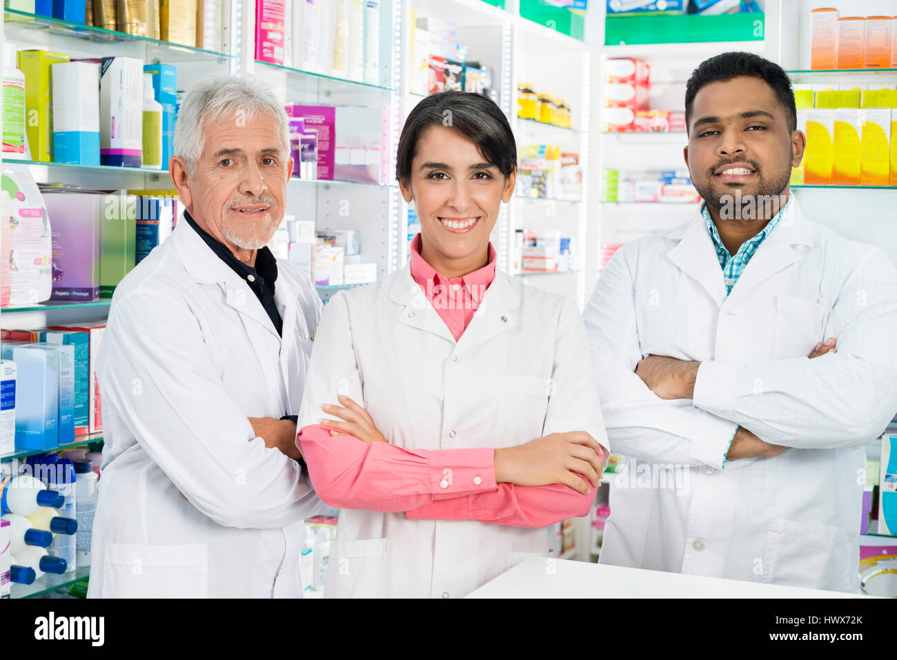 Portrait d'hommes et femmes multiethniques chimistes standing arms crossed in pharmacy Banque D'Images