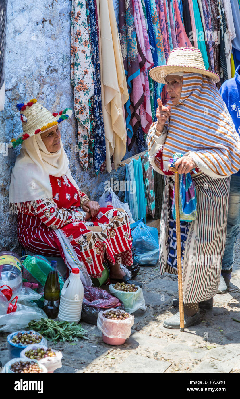Chefchaouen, Maroc. Deux femmes en costume traditionnel berbère parlé dans le marché. Banque D'Images