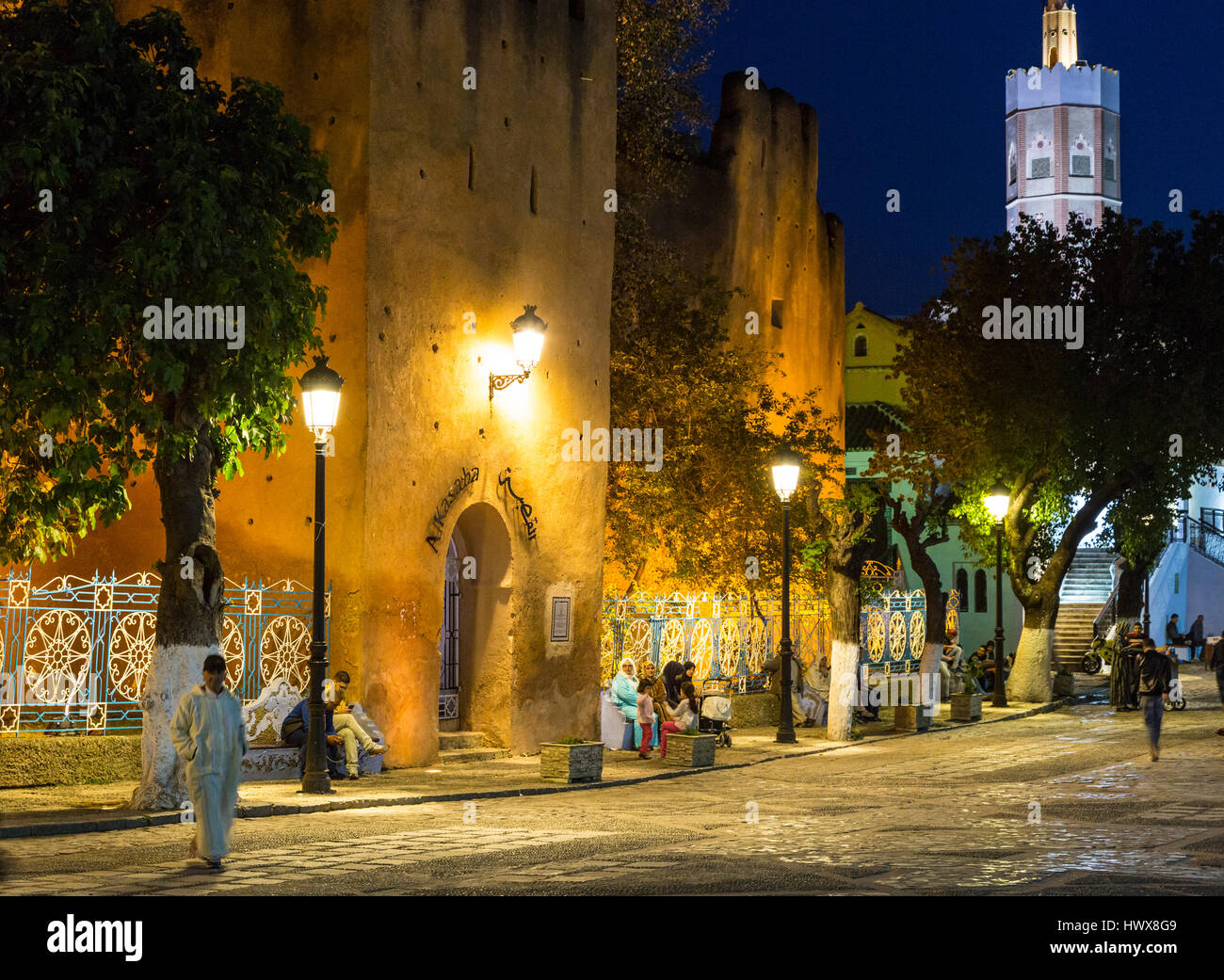 Chefchaouen, Maroc. Les gens se détendre dans la place Outa El-Hammam dans la soirée. Entrée de la Kasbah, construite 1471. Banque D'Images