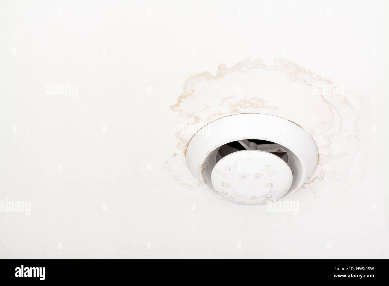 Châssis de ventilation d'air ronde sur plafond blanc avec des taches humides, des stries et moule autour de ventilateur. Banque D'Images