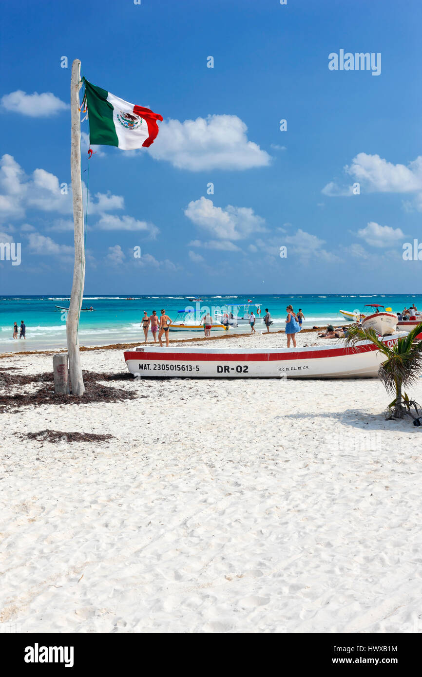 Drapeau et bateaux de pêche sur la plage de sable de Tulum, Mexique Banque D'Images