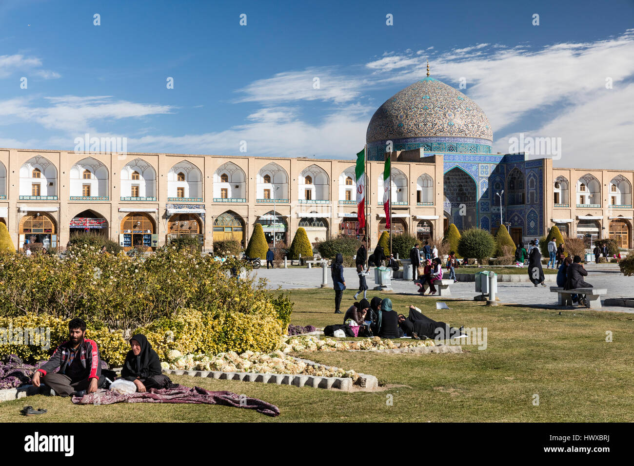 Place Imam à Isfahan avec les visiteurs, y compris les pique-niqueurs, tchador-femmes, et le dôme de la mosquée cheikh Lotfallah Banque D'Images