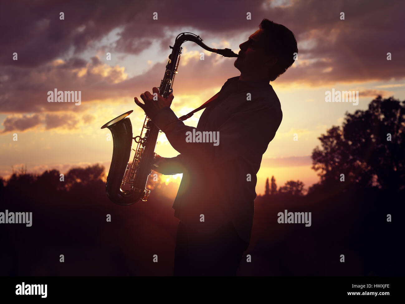 Saxophoniste saxophoniste ou l'exécution de sax contre coucher du soleil Banque D'Images